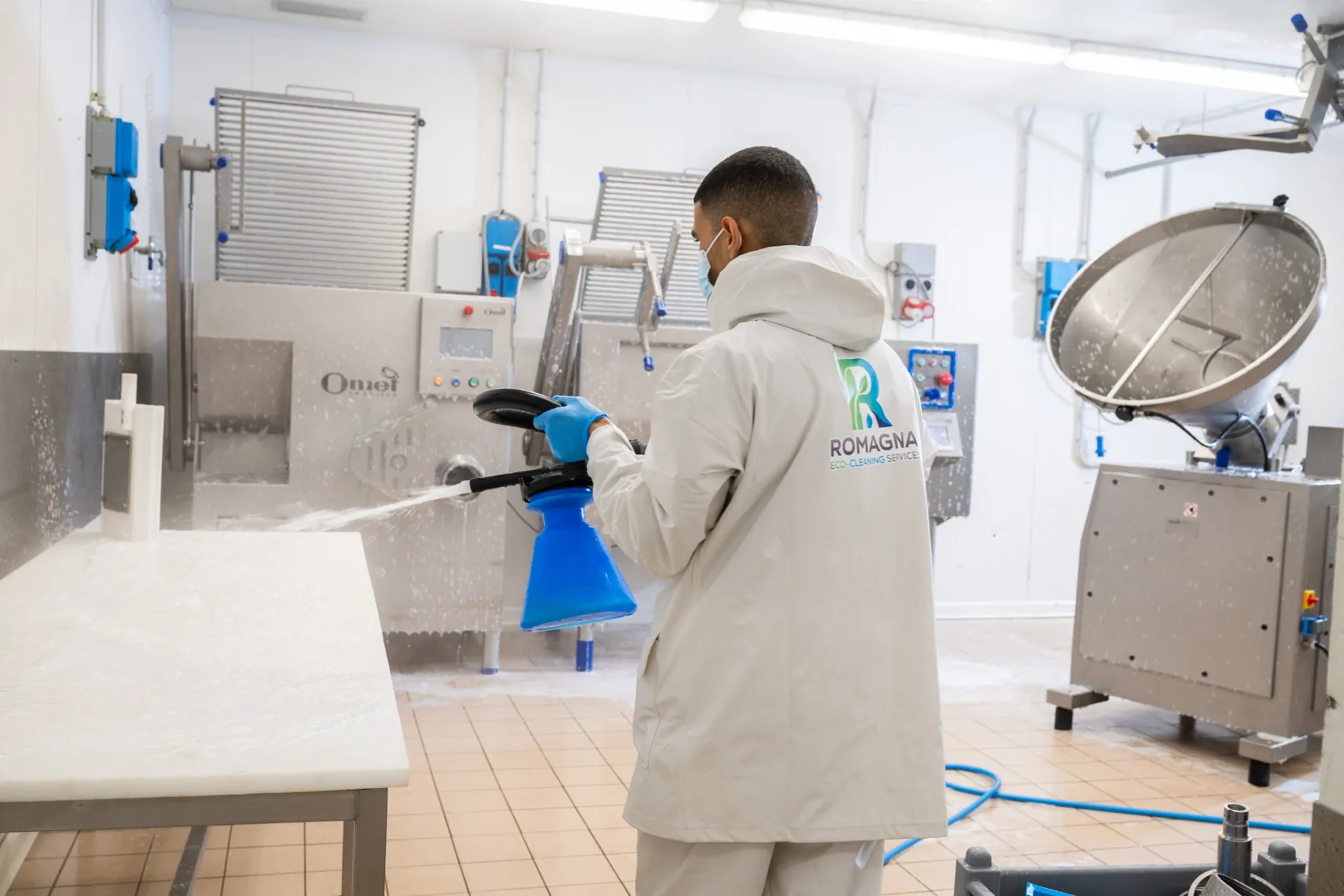 Operatore impegnato nella pulizia di macchinari per la lavorazione alimentare
